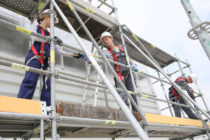 Construction,Workers,Installing,Scaffolding,On,Site